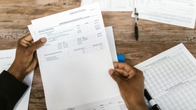 Mãos segurando documentos financeiros para análise e preparação tributária.