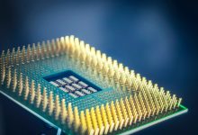 Imagem aproximada de um chip de computador com contatos dourados sobre fundo azul.