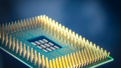 Imagem aproximada de um chip de computador com contatos dourados sobre fundo azul.