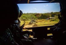 Militares observam uma área externa de dentro de um veículo blindado durante um exercício