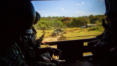 Militares observam uma área externa de dentro de um veículo blindado durante um exercício