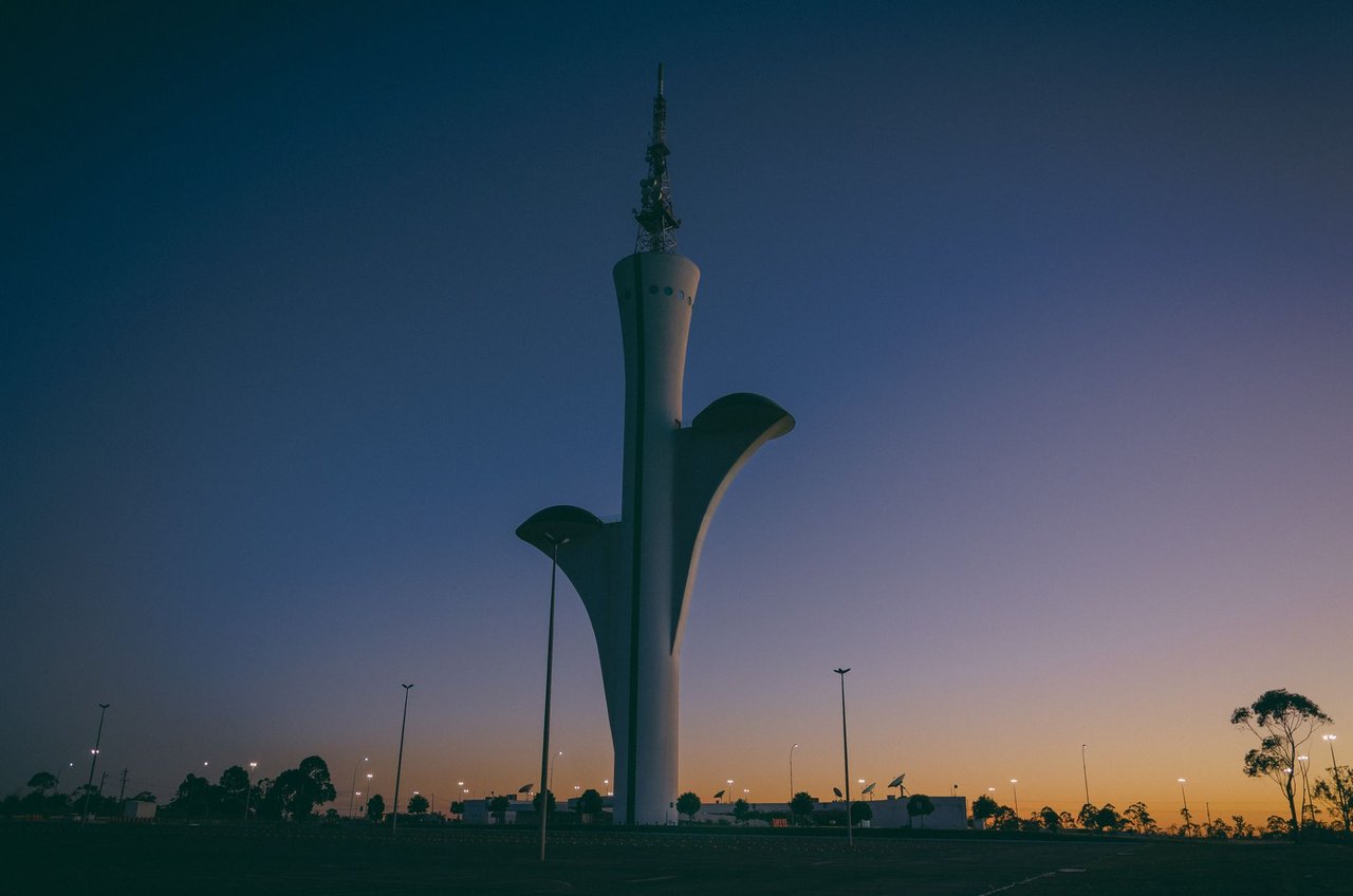 Torre de TV digital de Brasília silhuetada contra o céu ao entardecer